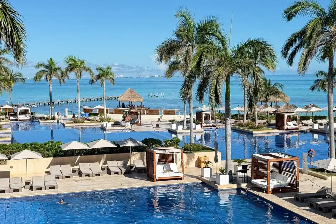 Resort pool deck with palms, cabanas and the Caribbean behind