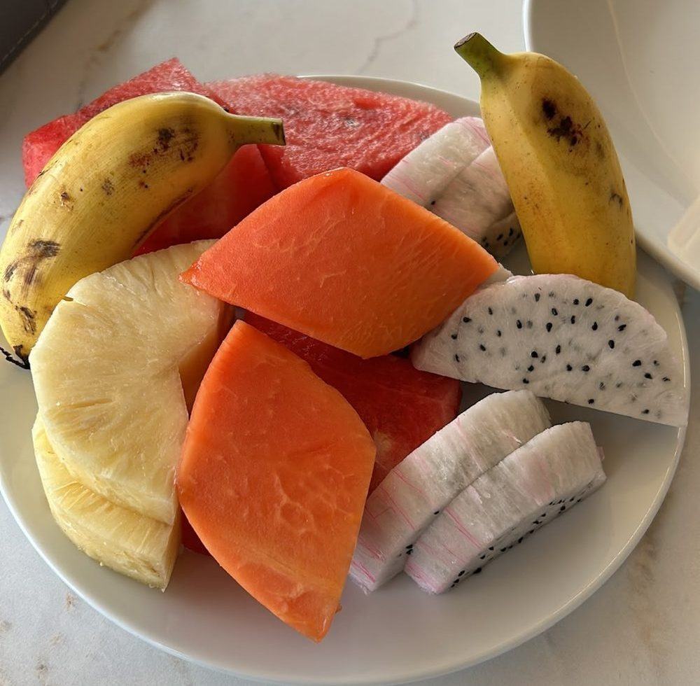 Plate of papaya, pineapple, watermelon, dragon fruit and small bananas