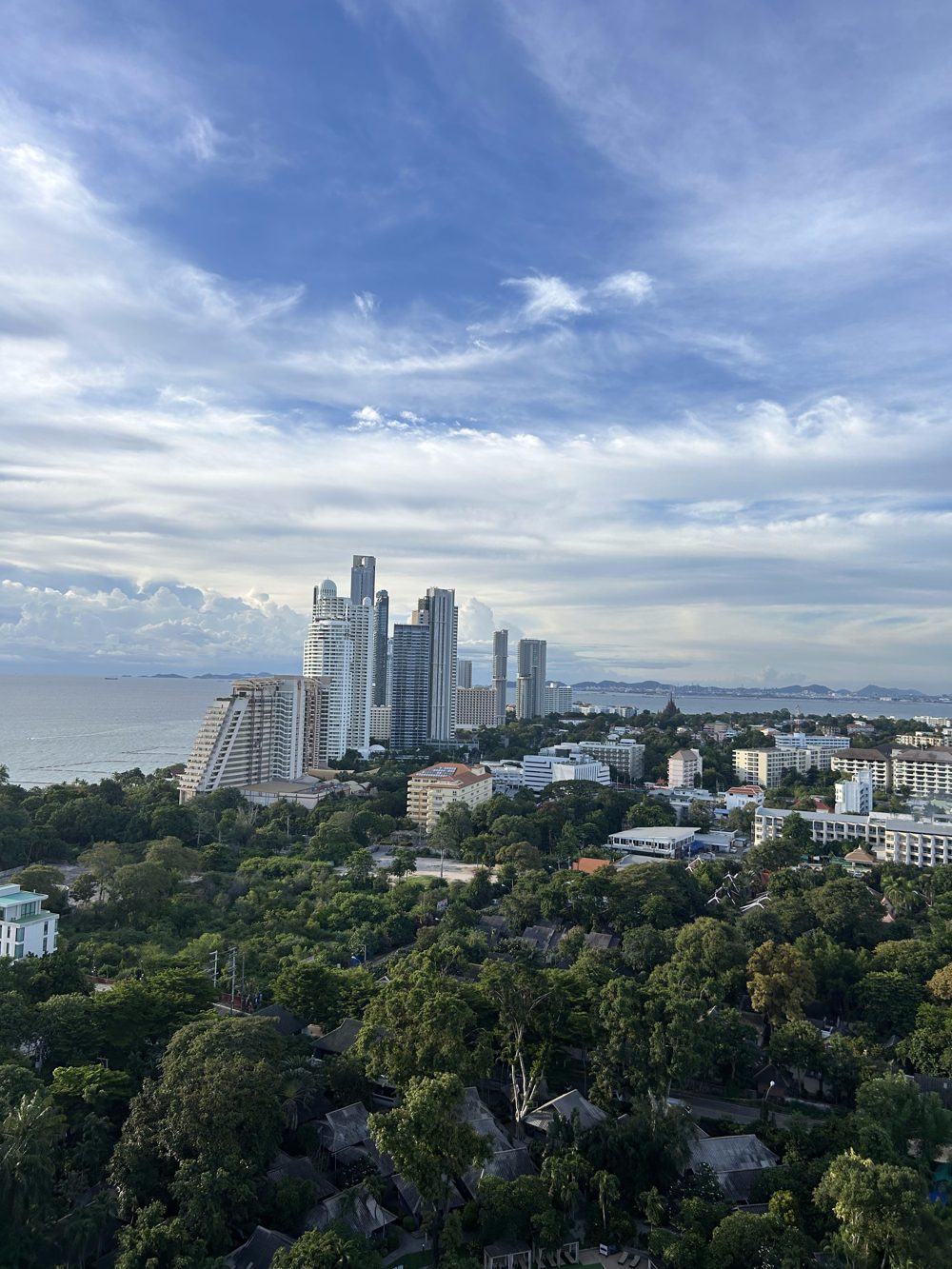 Pattaya skyline with tall buildings and the sea under a blue sky